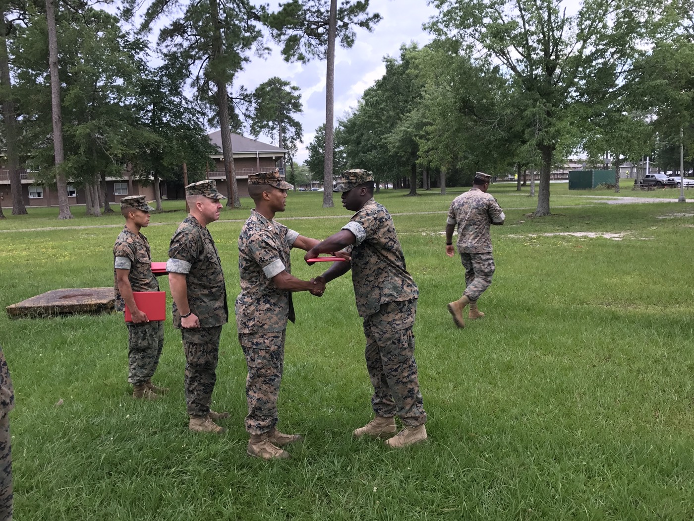 Jalphy shaking hands with his commanding officer while receiving his meritorious promotion